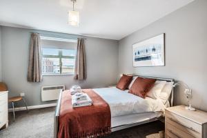 een slaapkamer met een bed en een raam bij Merchants Gate York City Apartments in York