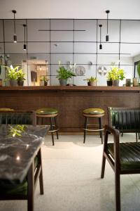 a restaurant with chairs and a counter with plants at Hotel Botanica in Belgrade