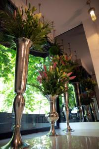 Hotel Botanica في بلغراد: ثلاث مزهريات عليها ورد على طاولة