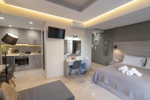 a bedroom with a bed and a desk and a kitchen at Αqua Dream Beach Apartment in Kos