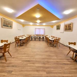 Habitación grande con mesas y sillas de madera. en Hotel Da Sabino, en Singen