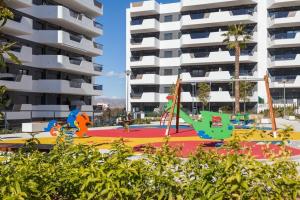 um parque infantil em frente a um edifício de apartamentos em APARTAMENT GAUDI em Arenales del Sol