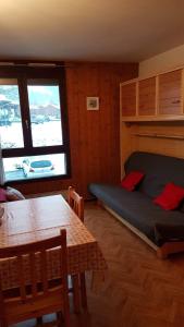 um quarto com uma cama, uma mesa e uma janela em Studio les Houches. Vallée de Chamonix em Les Houches