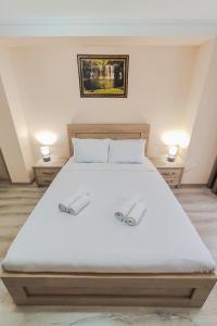 ein Schlafzimmer mit einem großen weißen Bett mit zwei Lampen in der Unterkunft Hotel Pushkin II/1a in Kutaissi