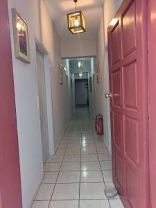 a hallway with a red door and a tile floor at Pension Irene in Sougia