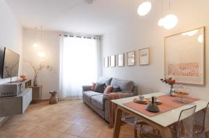 ein Wohnzimmer mit einem Sofa und einem Tisch in der Unterkunft Casa del Borgo "Terra & Fuoco" sul Lago Maggiore in Maccagno Inferiore