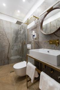 a bathroom with a sink and a toilet and a mirror at Bošket Luxury Rooms in Split