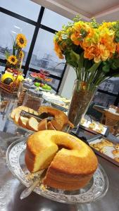 a table with two plates of bread and a vase of flowers at Hotel Universal in Santarém