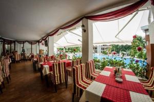 a restaurant with tables and chairs and a pool at Messambria Fort Beach - Premium Apartments in Elenite
