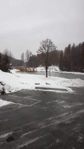 um parque de estacionamento vazio com neve no chão em Studio les Houches. Vallée de Chamonix em Les Houches