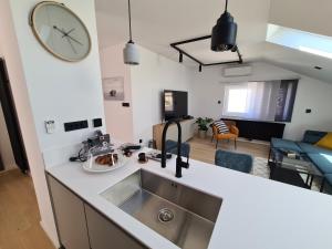a kitchen with a sink and a living room at Romantic Guesthouse Porto close to Sandy beach in Crikvenica