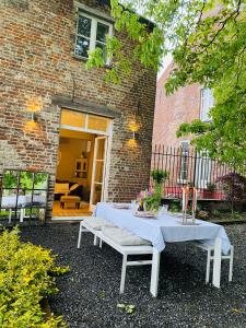 a table and bench in front of a brick building at Cosy house in a charming village in Beauvechain