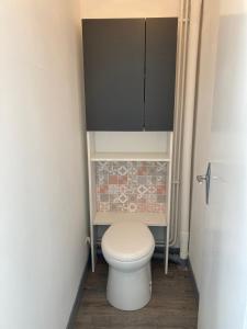a small bathroom with a toilet and a cabinet at F2 Vire centre in Vire