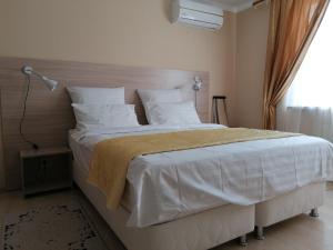 エッセントゥキにあるGuest House U Yuliのベッドルーム1室(大型ベッド1台、白いシーツ、枕付)