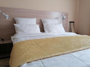 エッセントゥキにあるGuest House U Yuliの白いシーツと枕が備わる大きな白いベッド