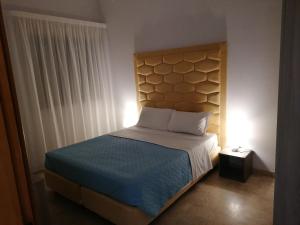 a bedroom with a bed with a headboard and a lamp at Zibibbo Beach Apartments - Trapani in Trapani