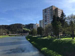 a river in a city with a tall building at Sunny appartment by the river in Dolný Kubín