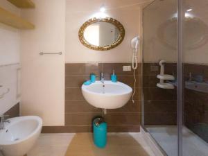 a bathroom with a sink and a shower with a mirror at Donna Maria b&b in Favignana