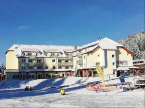 ein großes Gebäude mit einer Skipiste im Schnee in der Unterkunft Feldberg Lodge Holidays - Residenz Grafenmatt in Feldberg