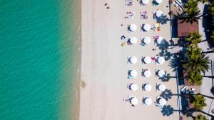 uma vista superior de uma praia com guarda-sóis e do oceano em Tridente Mare Apart Hotel em Pefkohori