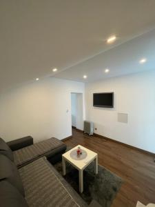 uma sala de estar com um sofá e uma mesa em Studio privée Vesoul -Wifi,TV,Clim em Vesoul