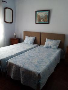 a bedroom with two beds and a mirror on the wall at Dona Julia in Santa Cruz das Flores
