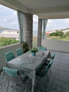 a table and chairs on a patio with a view of the ocean at Big Blue - Xenija (Veliko Plavetnilo - Ksenija) in Metajna