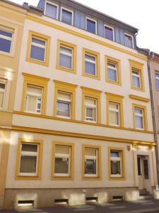 a yellow building with many windows on a street at City-Pension-Bautzen in Bautzen