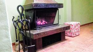 a fireplace in a living room with a fire in it at Palácio do Sol Hostel Pousada in São Thomé das Letras