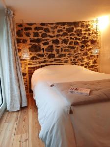 a bedroom with two beds and a stone wall at Charmant logement T2 à 2 pas de la mer in Granville
