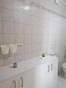 a white bathroom with a sink and a toilet at Big Blue - Xenija (Veliko Plavetnilo - Ksenija) in Metajna