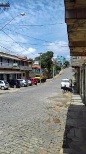 Palácio do Sol Hostel Pousada في ساو ثومي داس ليتراس: شارع فيه سيارة متوقفة على جانب الطريق