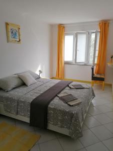 a bedroom with a large bed and a window at Big Blue - Xenija (Veliko Plavetnilo - Ksenija) in Metajna