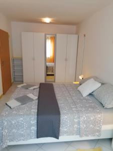 a bedroom with a large bed with white cabinets at Big Blue - Xenija (Veliko Plavetnilo - Ksenija) in Metajna
