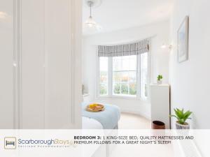 a white room with a table and a white refrigerator at Scarborough Central Townhouse in Scarborough