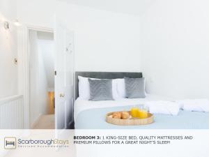 a white bed with a tray of donuts on it at Scarborough Central Townhouse in Scarborough