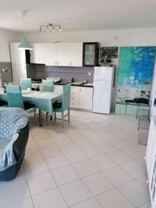 a kitchen and dining room with a table and chairs at Big Blue - Xenija (Veliko Plavetnilo - Ksenija) in Metajna
