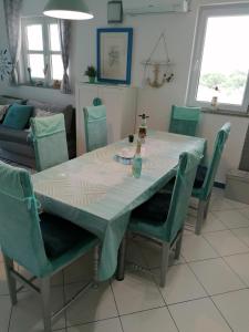 a dining room with a table and chairs and a couch at Big Blue - Xenija (Veliko Plavetnilo - Ksenija) in Metajna