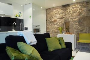 a living room with a couch and a stone wall at Green Home in Santiago de Compostela