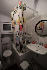 La salle de bains est pourvue d'un lavabo, de toilettes et d'un miroir. dans l'établissement The House on the Coast, à Évdhilos