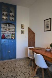 una sala da pranzo con armadio blu e tavolo in legno di The House on the Coast a Evdilos