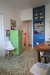 uma cozinha com um frigorífico verde e uma mesa em The House on the Coast em Evdilos