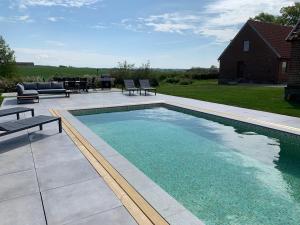 a swimming pool in a yard with chairs and a house at Villa Baldringe in Ystad