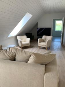 a living room with a couch and two chairs at Villa Baldringe in Ystad