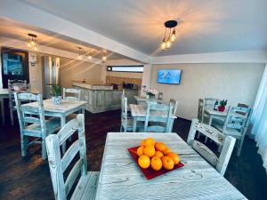 ein Esszimmer mit einem Tisch, auf dem Orangen lagen in der Unterkunft CASA ANKELI in Buşteni