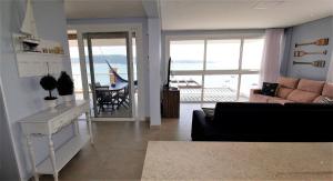 sala de estar con sofá y vistas al océano en 1080 - Apartamento com vista para o mar em Bombinhas, en Bombinhas