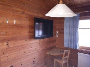 a room with a table and a tv on a wall at Ferienhaus Bruckner Hayingen Lauterdörfle in Hayingen