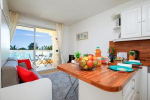 a kitchen with a table with a bowl of fruit on it at Sea Side YourHostHelper in Cannes