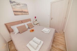 a small bedroom with a large bed with two pillows at Apartments Ruzmarin in Herceg-Novi