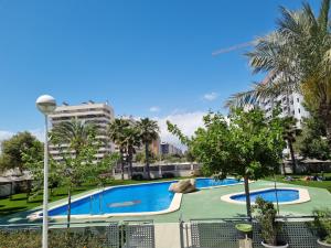 a large swimming pool with trees and buildings at Apartamento con vistas al mar in Alicante